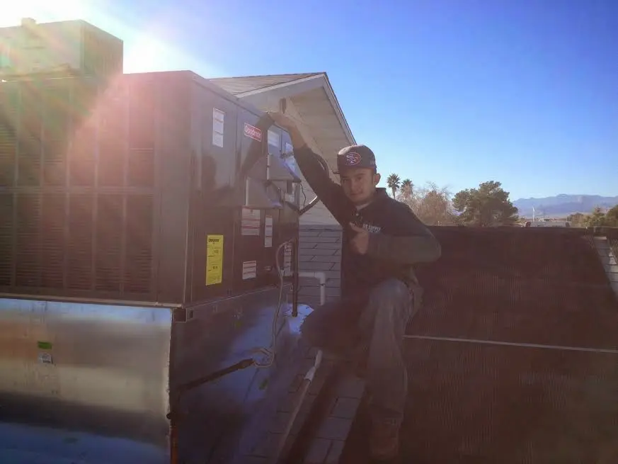 HVAC technician performing HVAC Inspection on a rooftop unit in Barre
